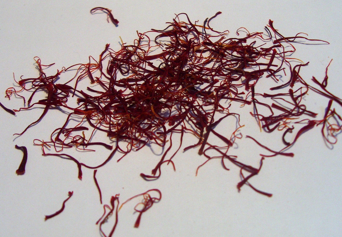 Dried dark red saffron threads on a light background