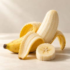 Representative one ripe yellow banana partly peeled, one thick circular banana slice imagery for fragrance-note discovery
