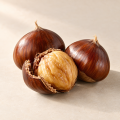 Representative three glossy brown chestnuts, one peeled to reveal pale golden flesh, with a small split husk imagery for fragrance-note discovery