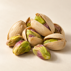 Representative a compact cluster of natural split-shell pistachios and exposed green-purple kernels imagery for fragrance-note discovery
