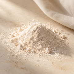 Representative a small soft mound of fine ivory cosmetic powder on warm ivory stone, gentle powder dust and a folded neutral cotton edge imagery for fragrance-note discovery